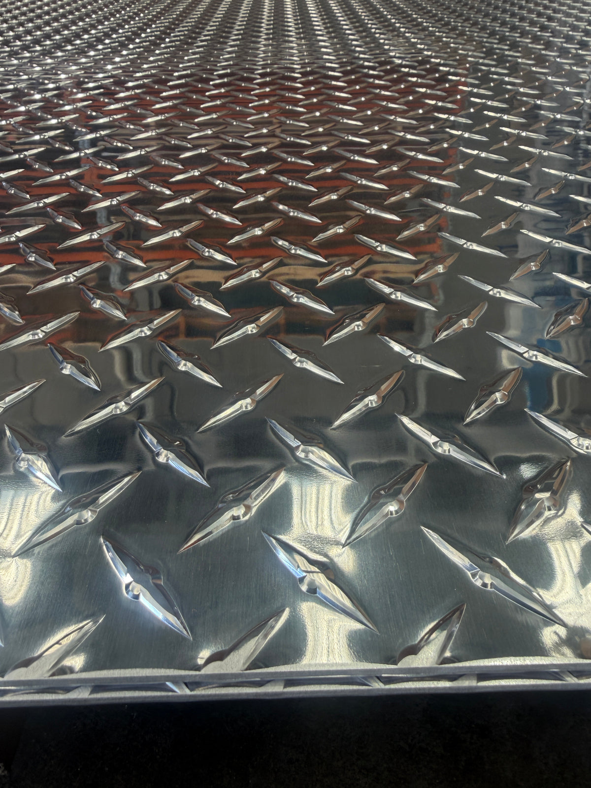 Aluminium treadplate sheet close-up showing the raised diamond tread pattern
